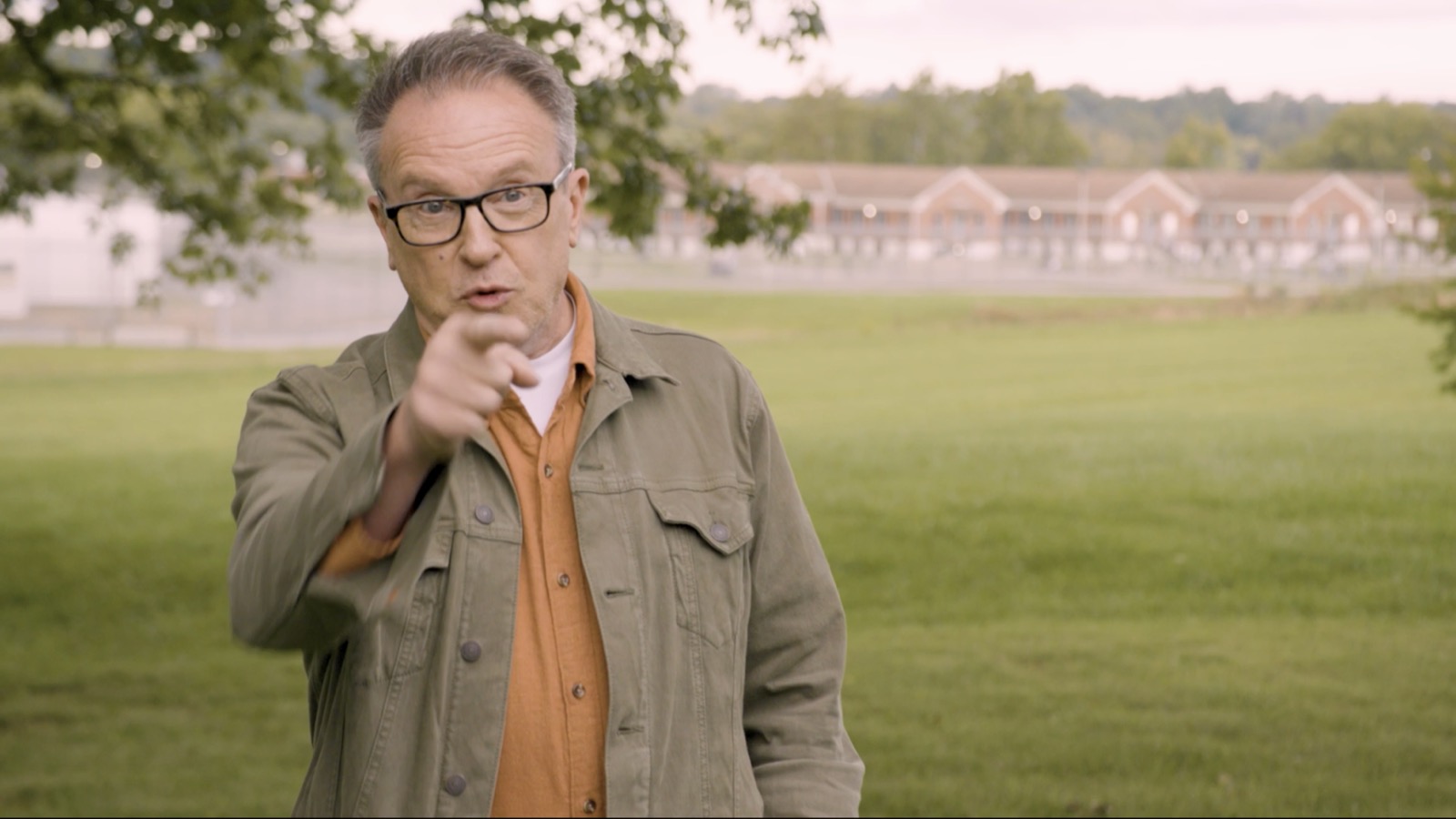 Harmony Project founder David Brown speaking outdoors on the grounds, pointing toward the camera.