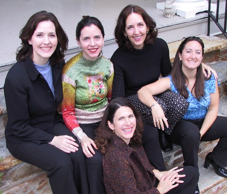 The five Burton sisters, producers of the film, sitting together on stone steps.